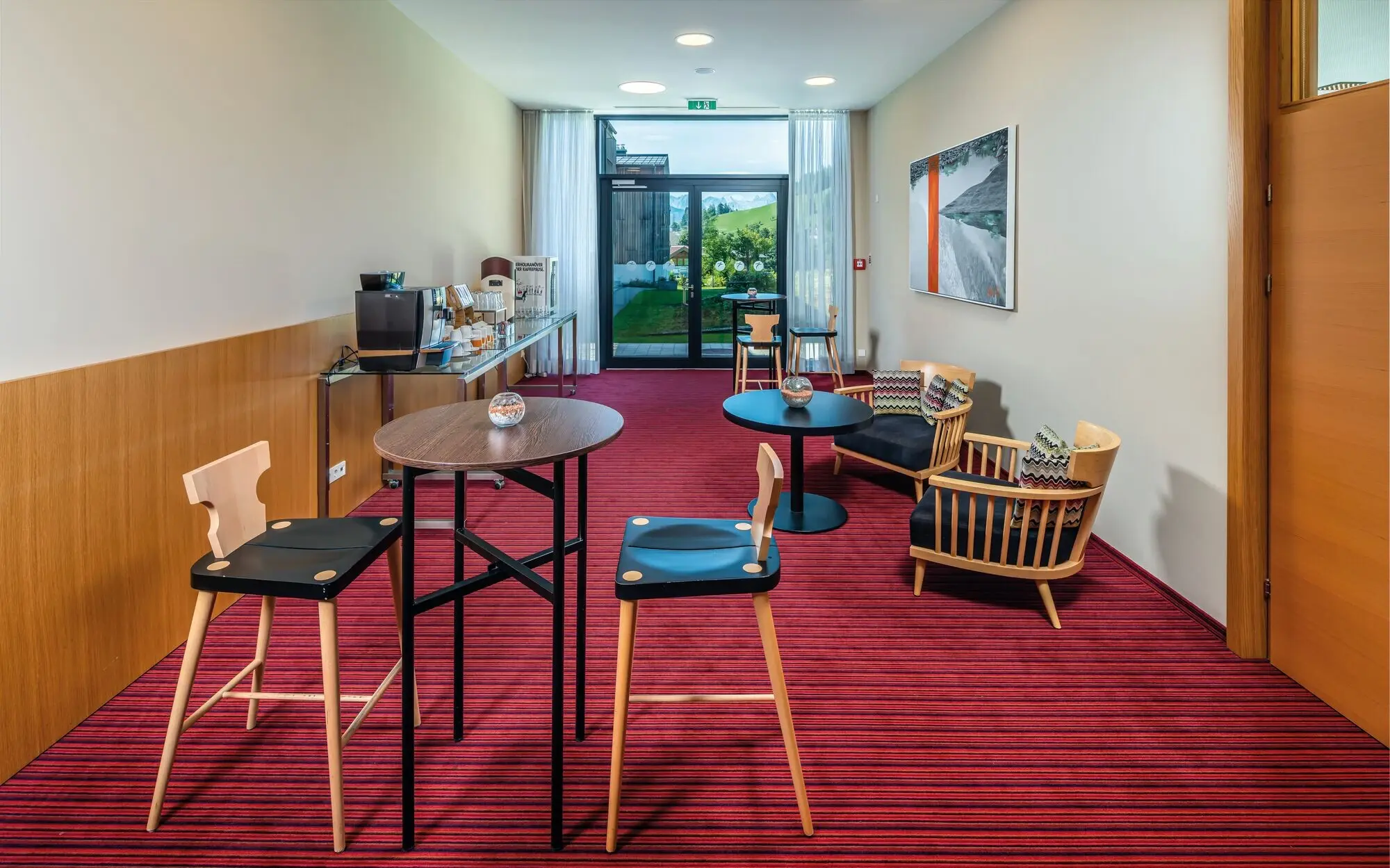 A room with tables and chairs, featuring a well-designed interior and visible flooring.