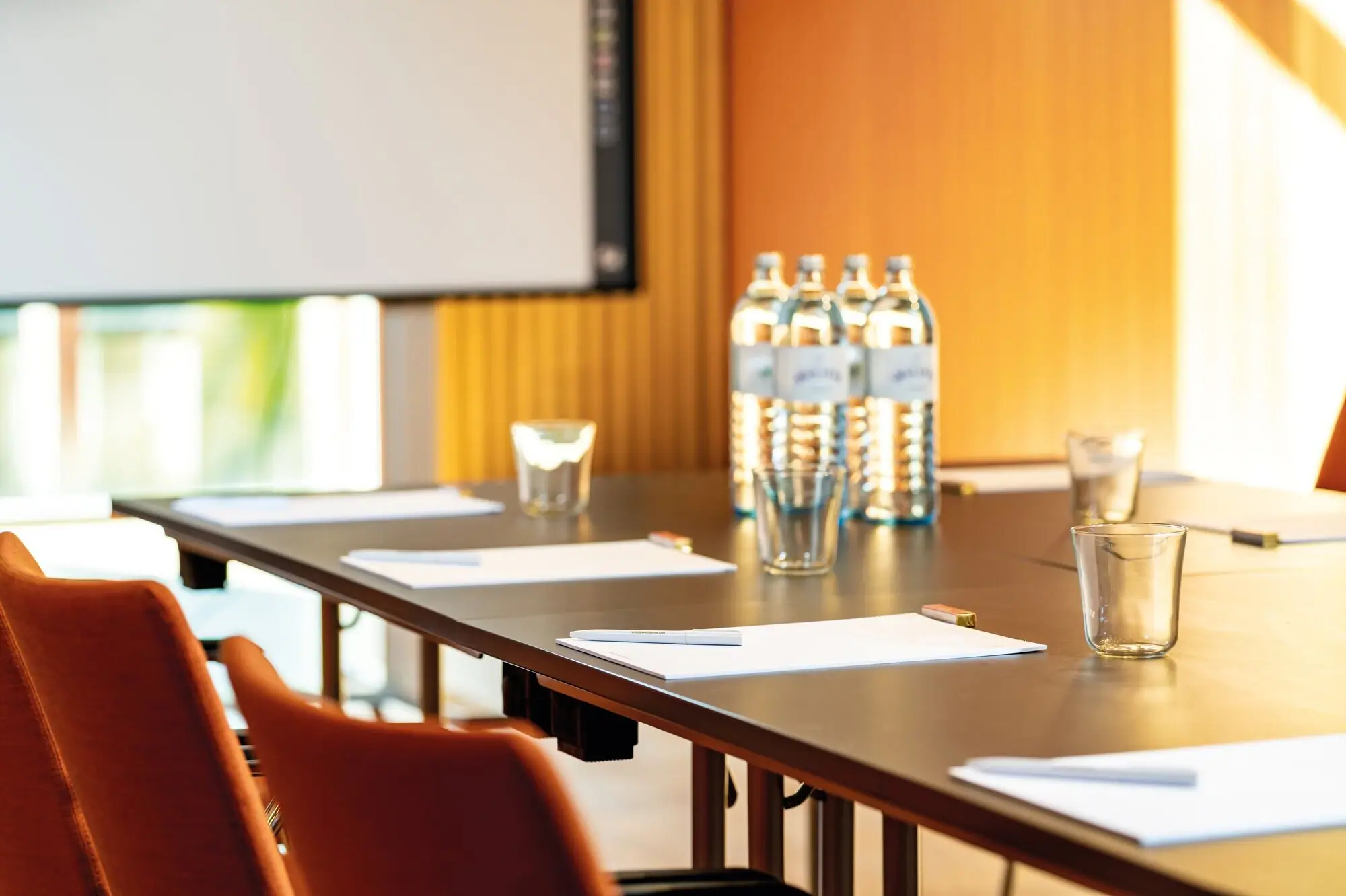 Conference room A table with papers and glasses on it.