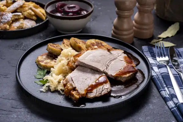 Meat dish A plate with food, a fork and a knife.