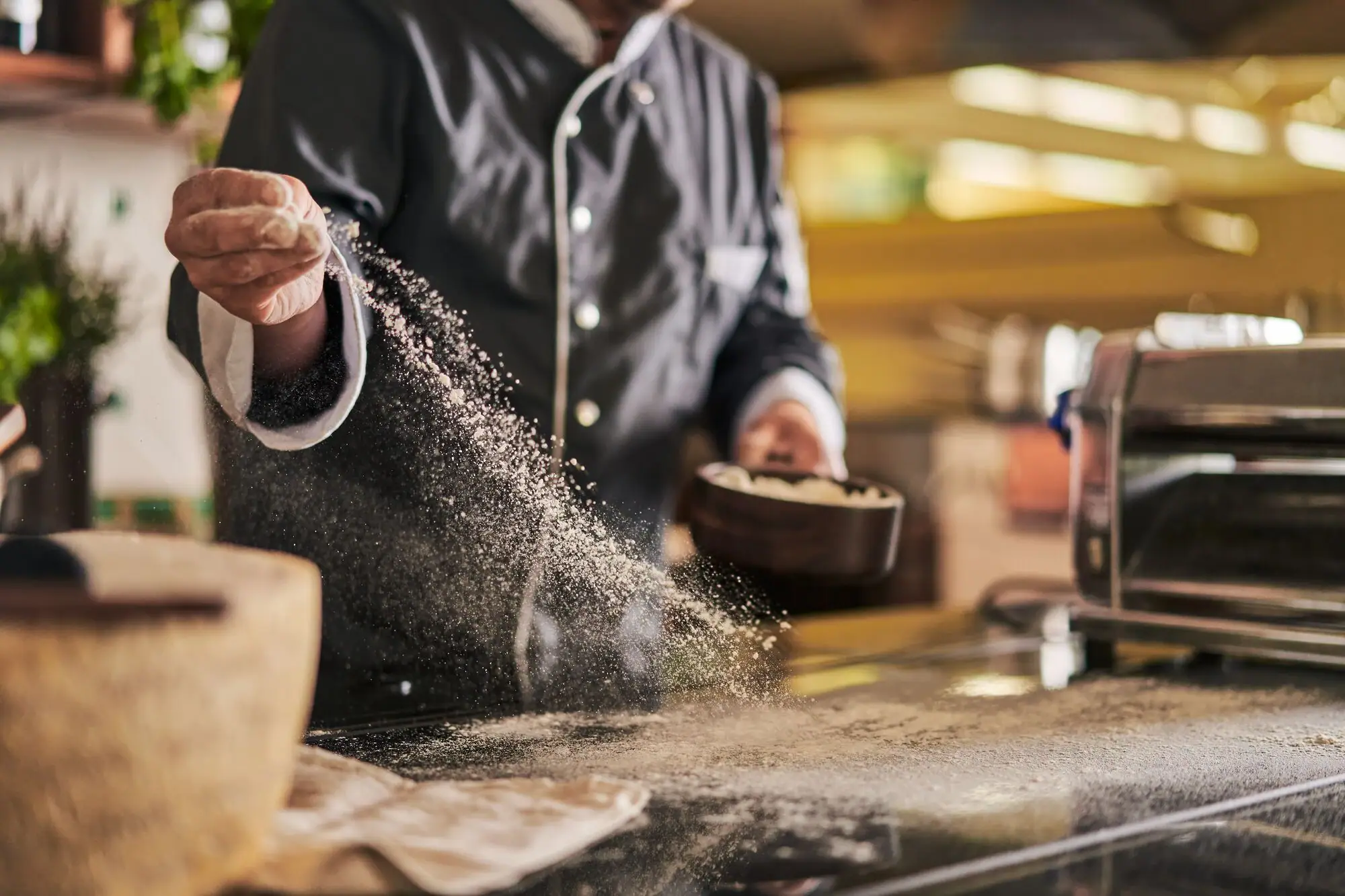 One person pours flour into a bowl.