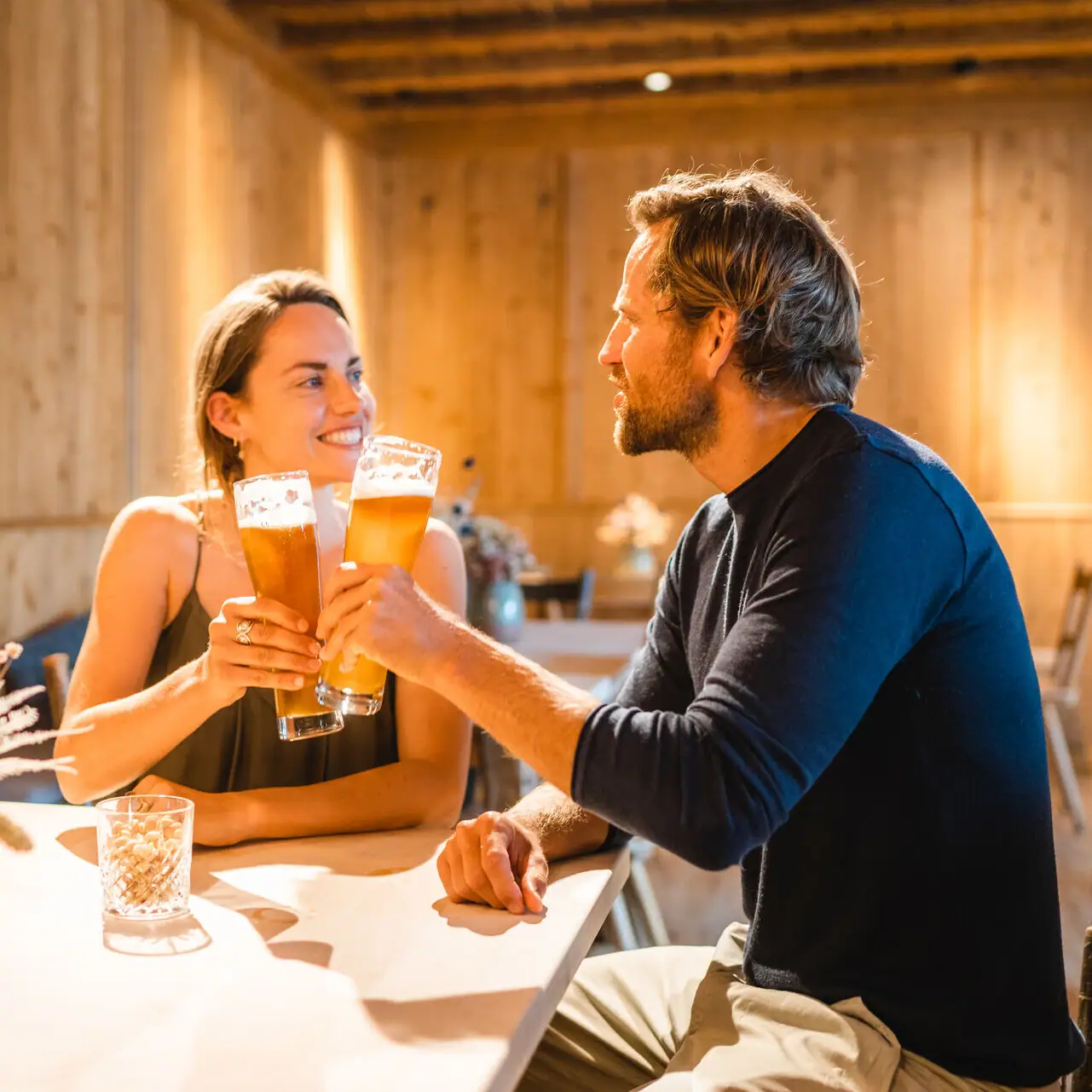 Bavarian parlour A man and a woman are sitting at a table with glasses of beer.