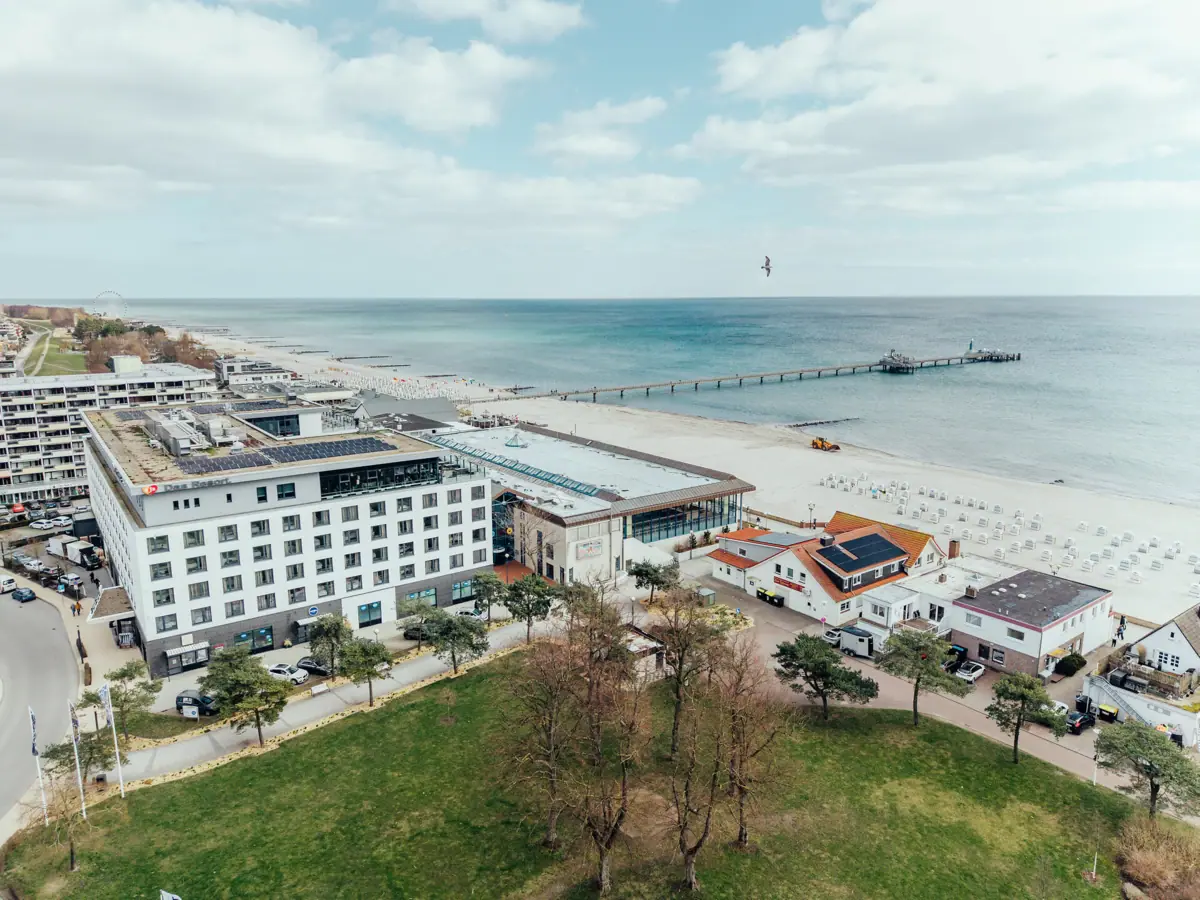 A beach with buildings and a pier in the foreground.