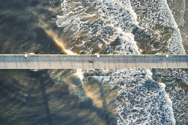 Pier A bridge over water with people walking on it