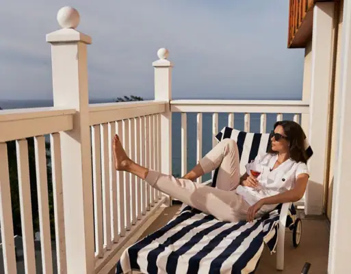 Balcony North Perd & Villas A woman sits on a chair on a deck.