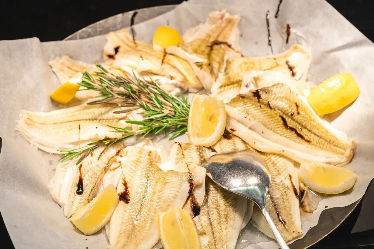 Fish A plate with fish and lemon slices, a spoon next to it.