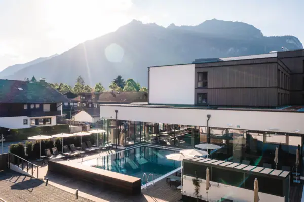 A pool in a building with a mountain in the background.