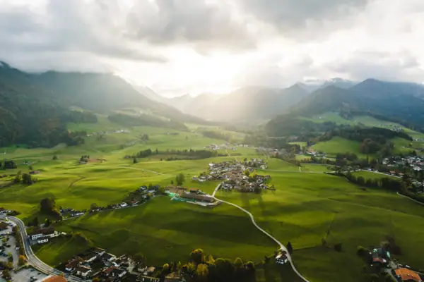 Ruhpolding Green landscape with mountains and buildings in the foreground.