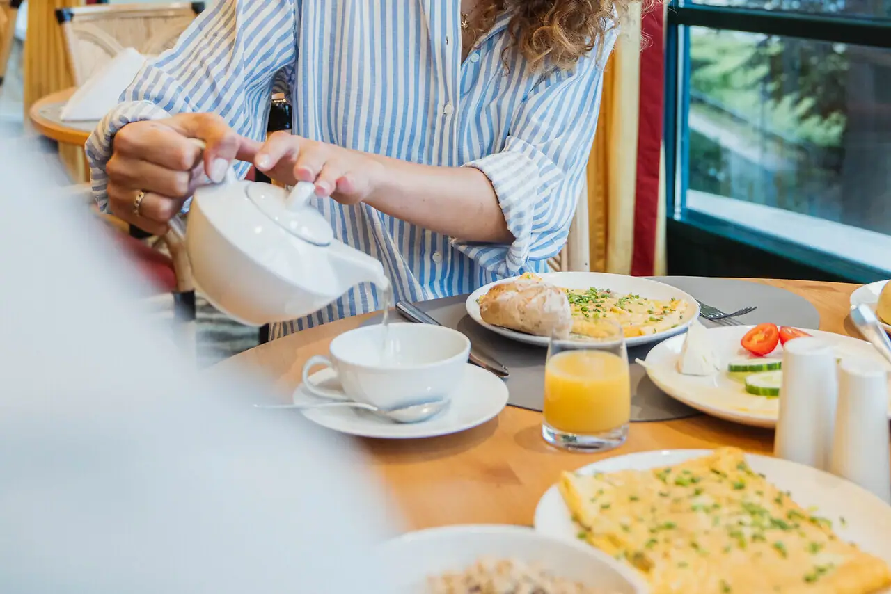 Tea A woman pours tea into a cup.