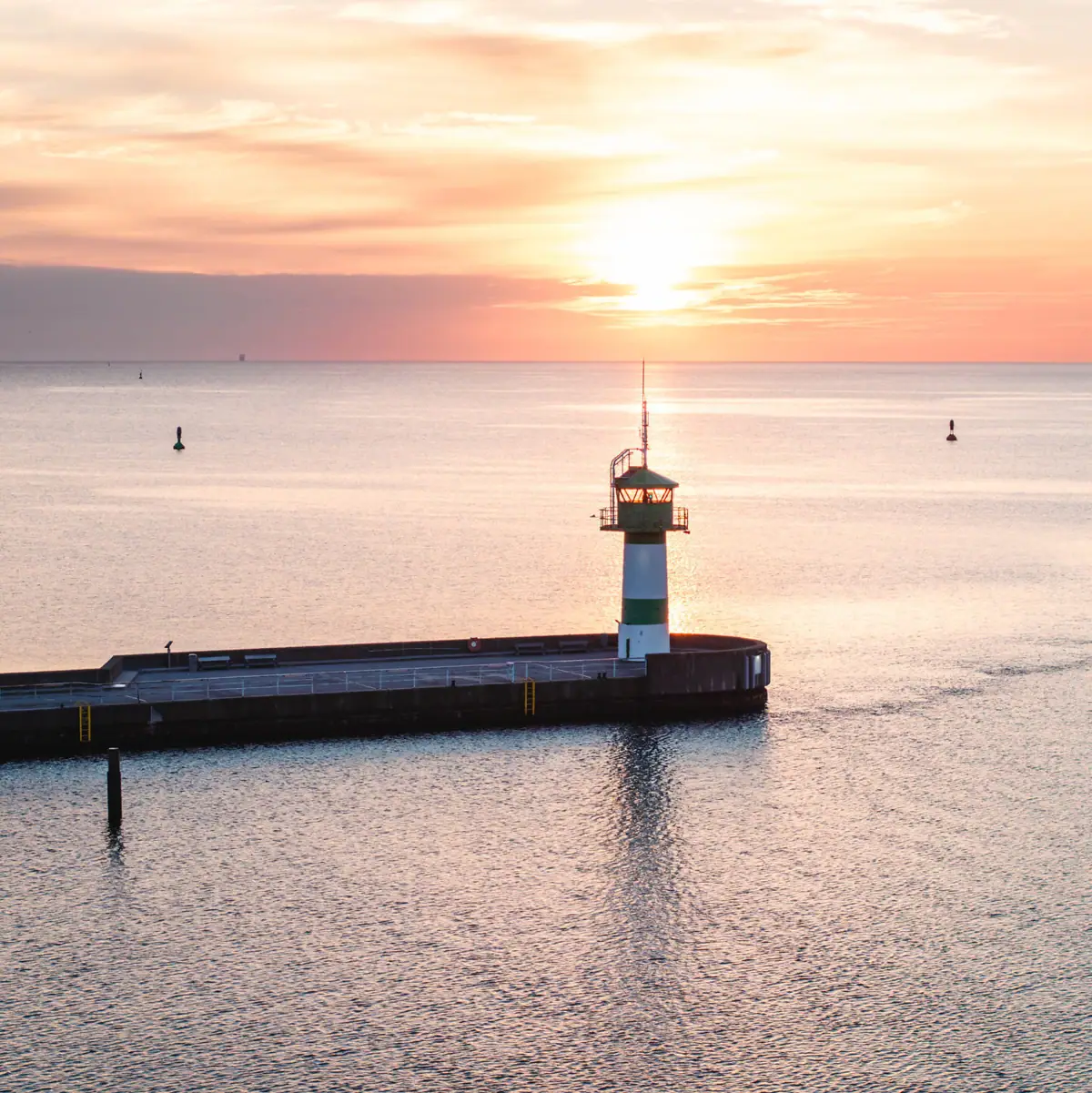 The green and white Nordermole with the water at sunrise.