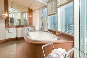 A bathroom with a large bathtub and washbasin.