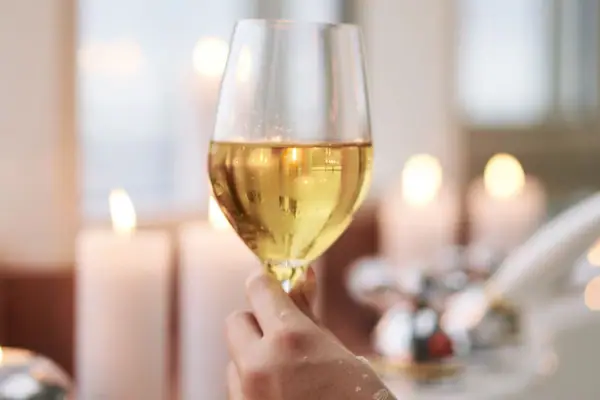 One hand holds a wine glass.