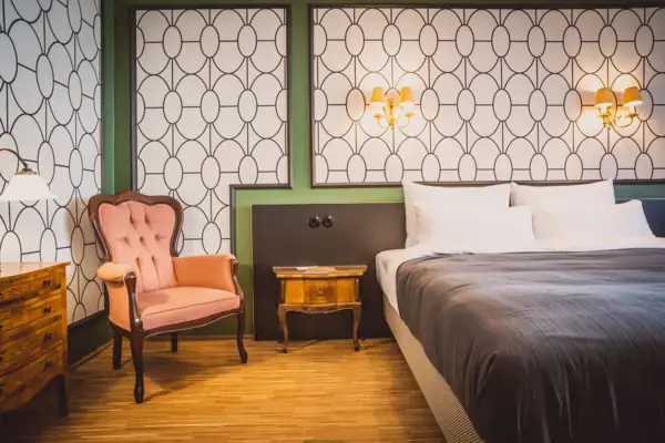 Rooms at HENRI Vienna A bedroom with a bed and a chair.