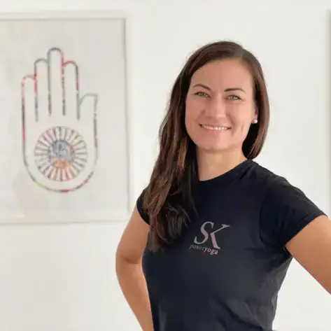 A smiling woman with her hand on her hip.
