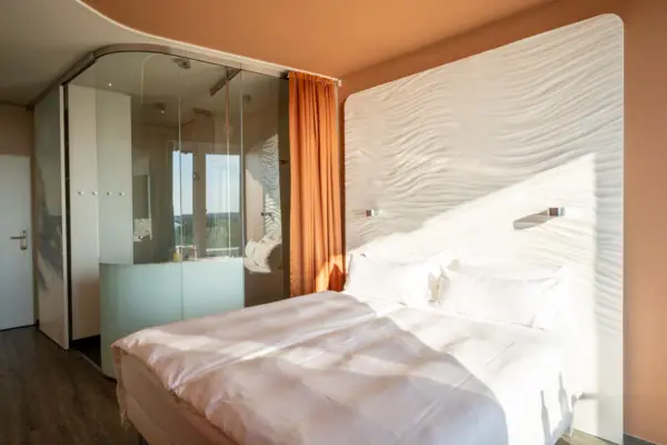 Bed with a glass wall in the background