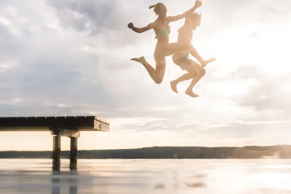 Jump Scharmützelsee A couple jumps into the water from a jetty.