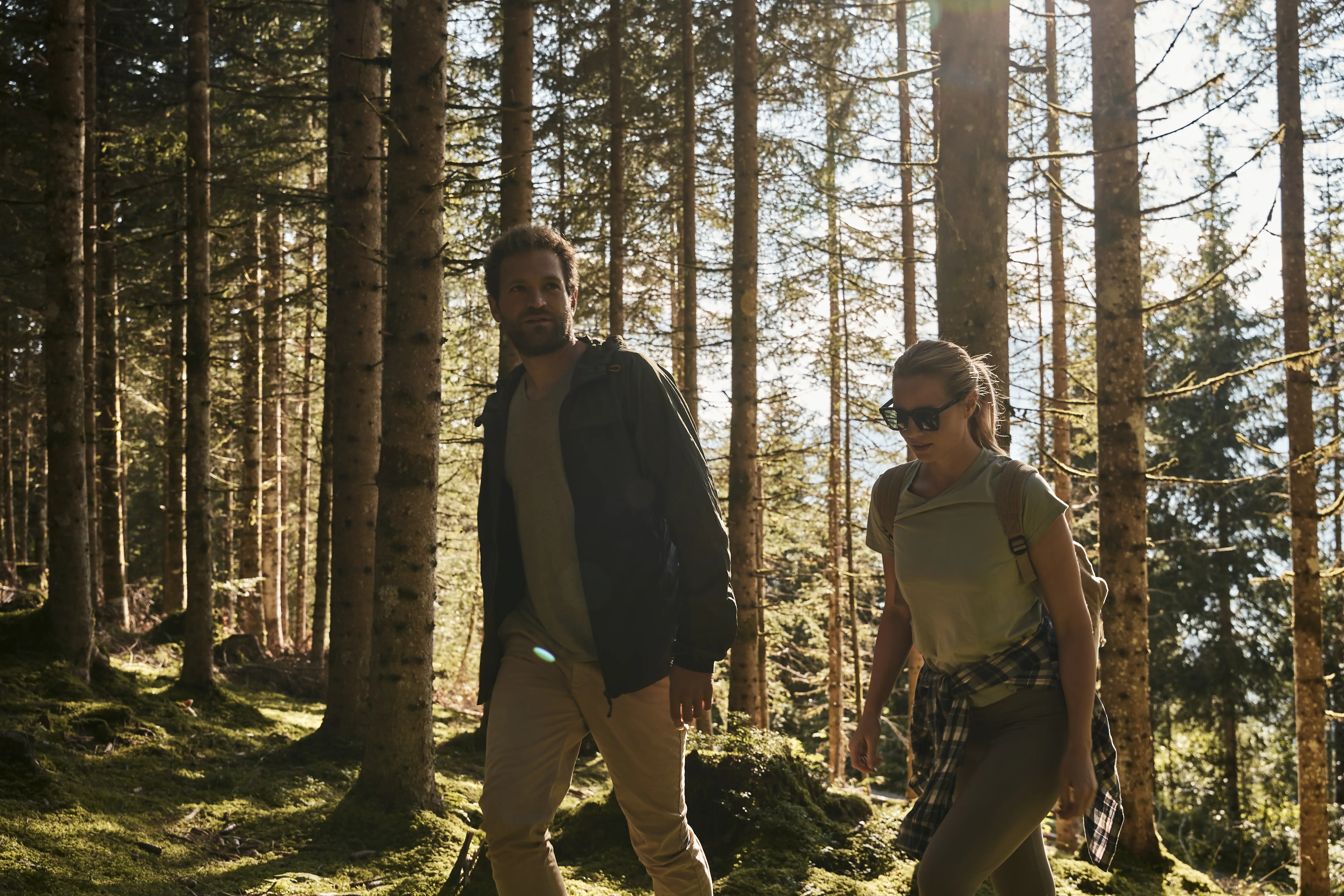 two hikers in the forest A man and a woman go for a walk in a forest.