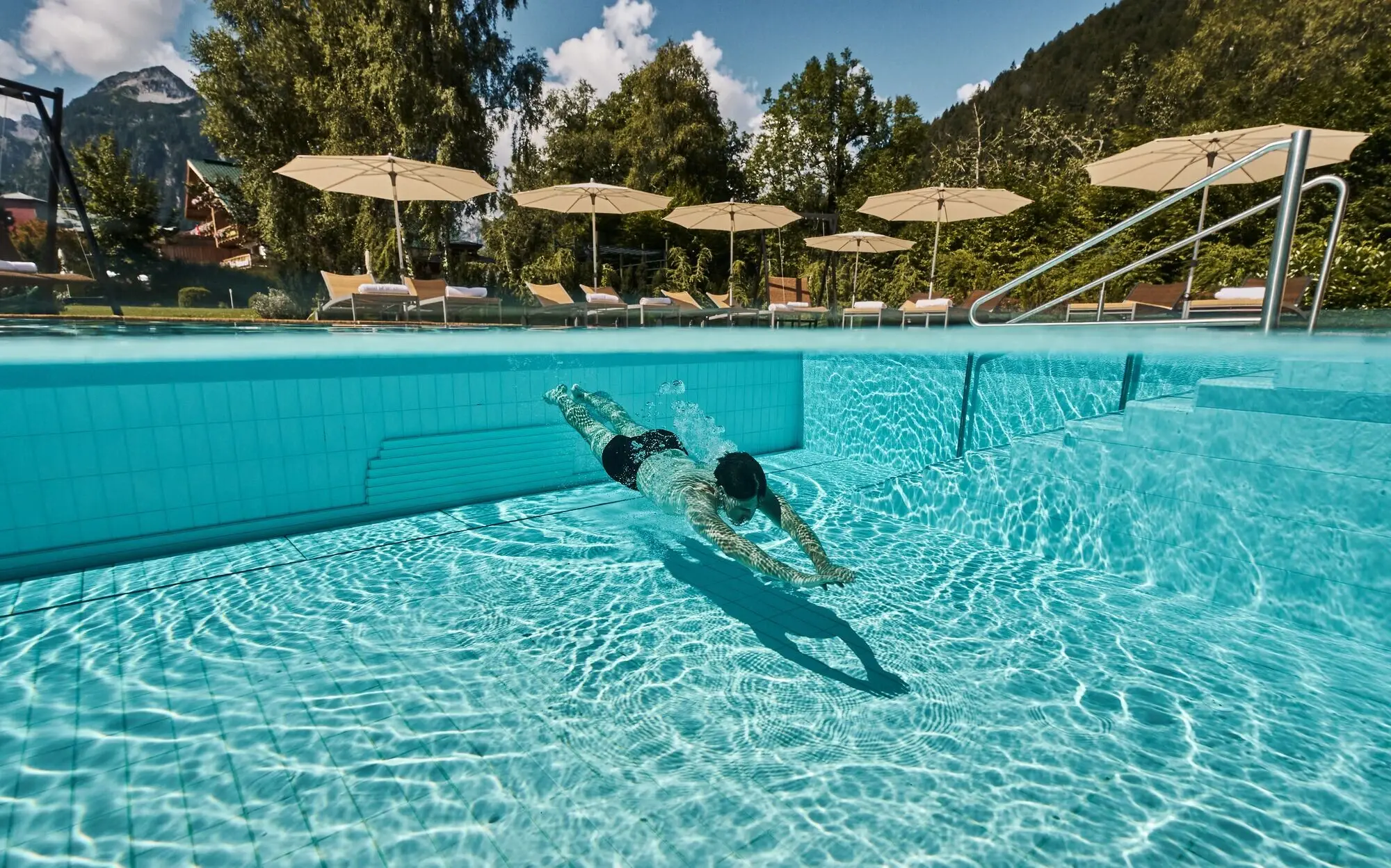 Person swims in an outdoor pool.