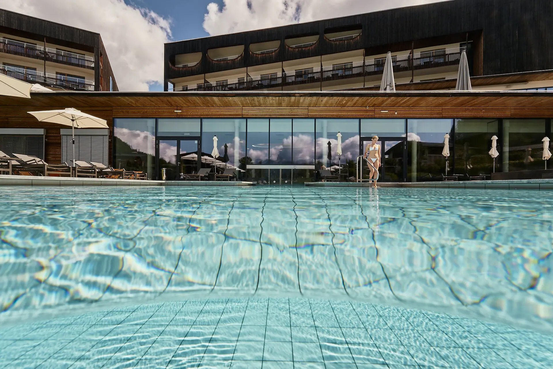 A swimming pool with the hotel in the background.