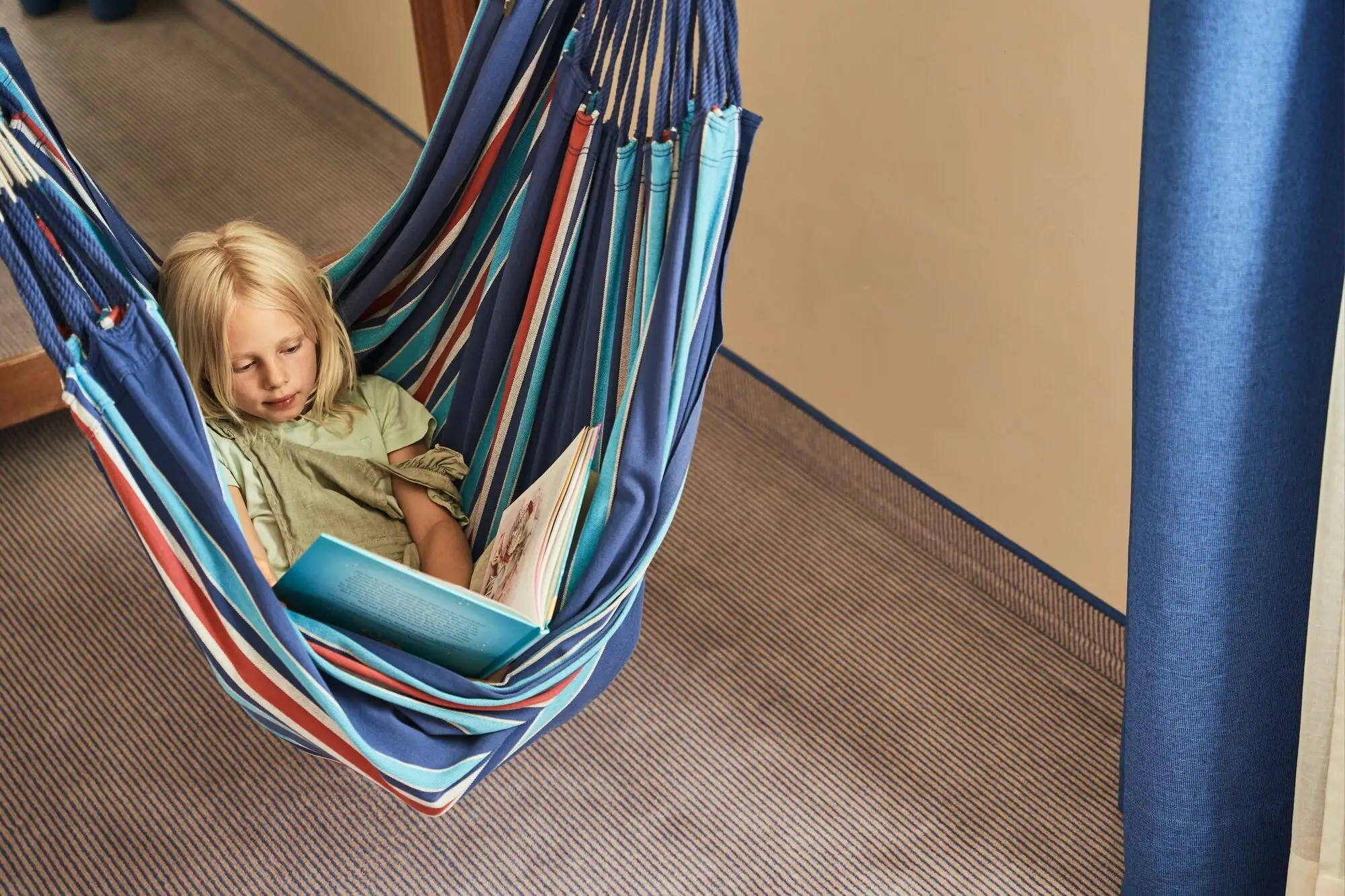 Girl reading a book in a hammock.