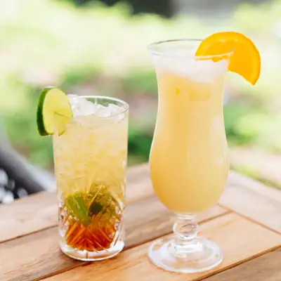 Drinks Two glasses with drinks on a table, one with a cocktail set.