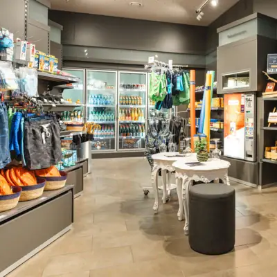 A small shop with shelves full of drinks.