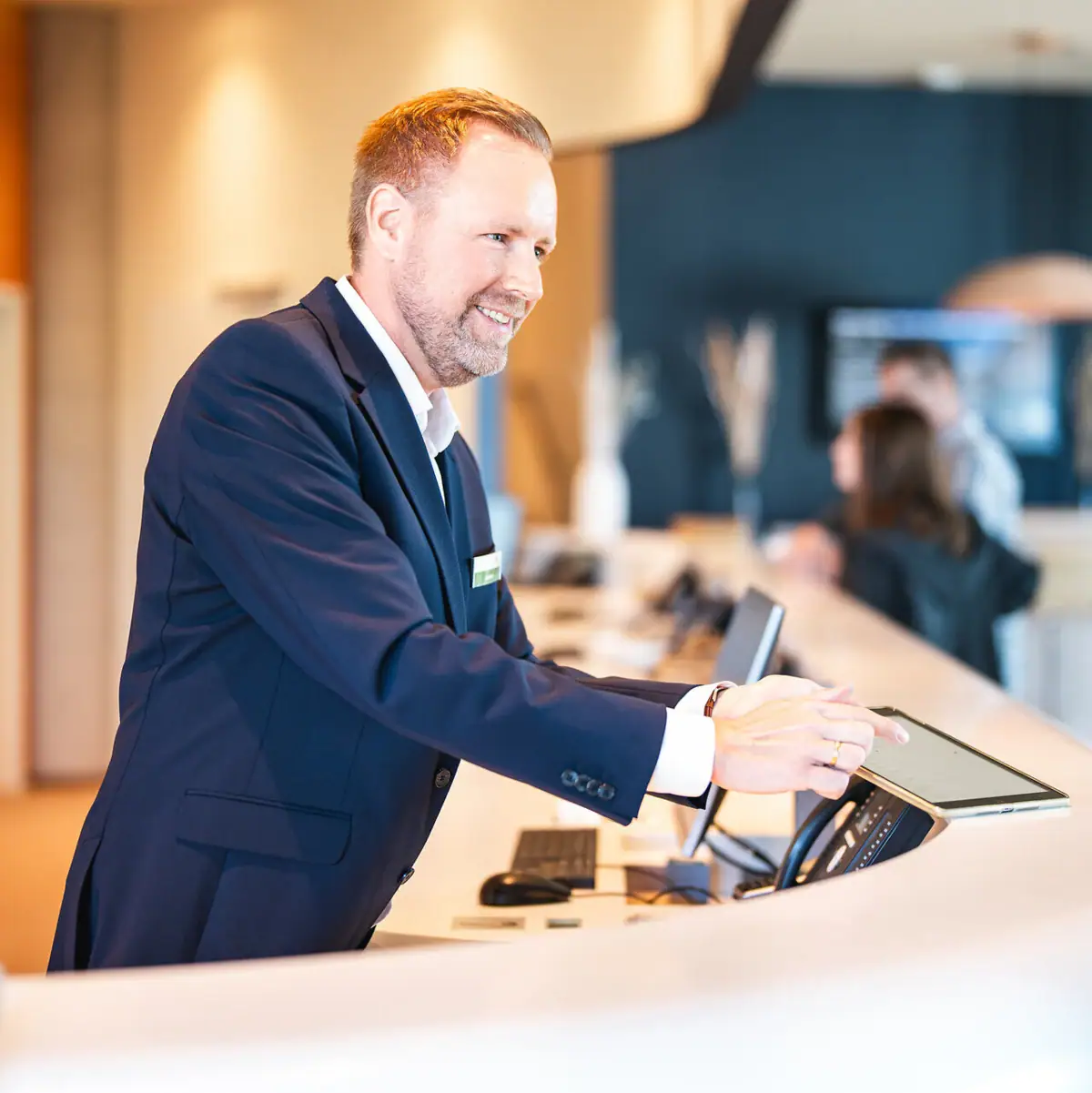 Reception A man is standing at a counter.