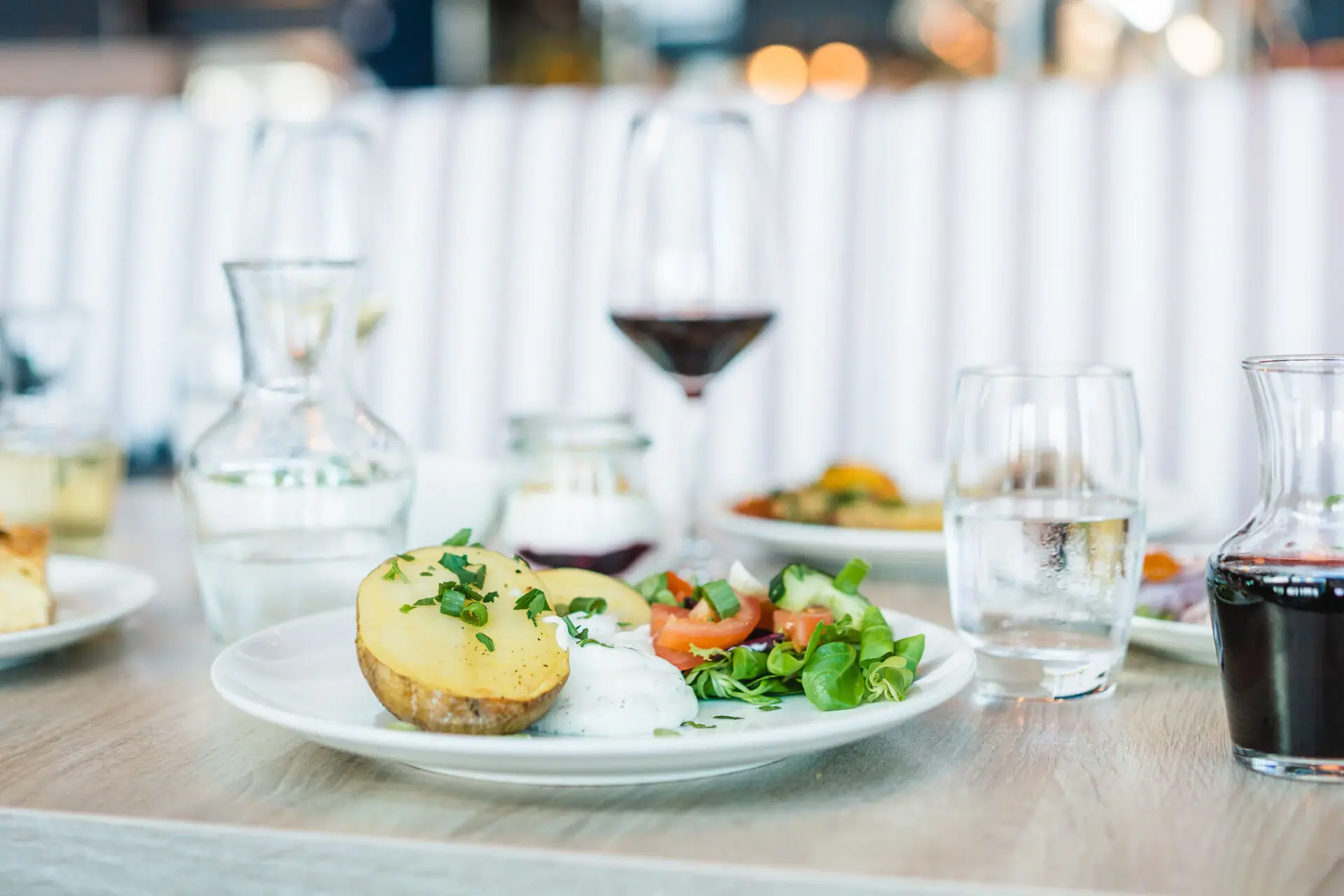 A plate of food on a table, a wine glass next to it.