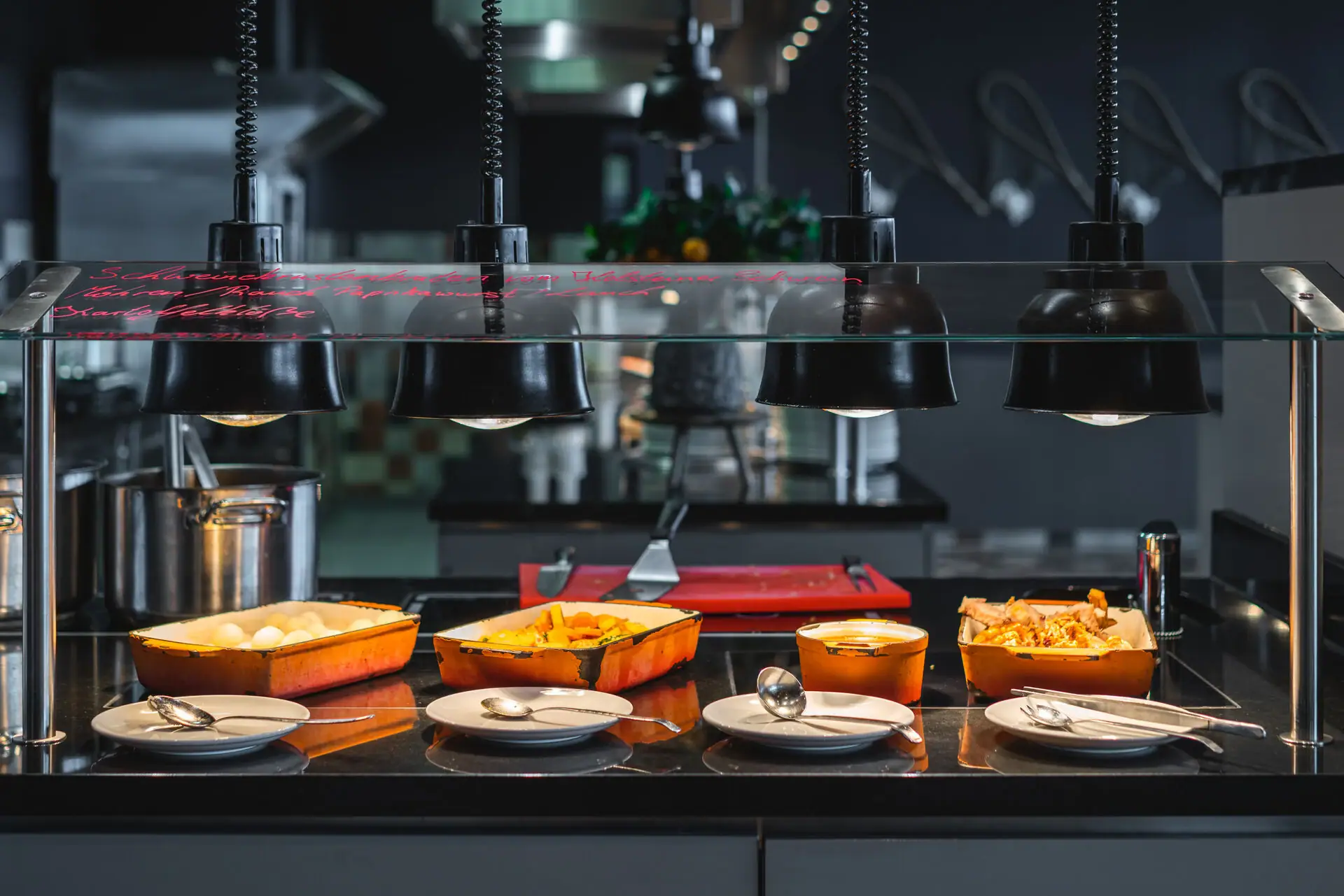 A buffet station with cast-iron pans filled with food.