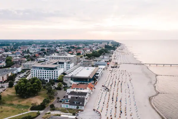 Bird's eye view of the beach with many beach chairs and buildings.