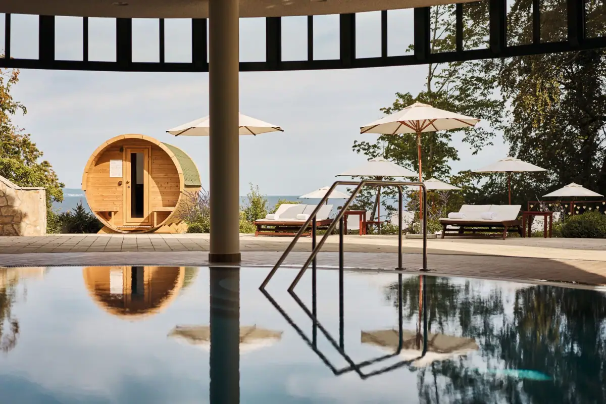 Pool with parasols and an outdoor barrel sauna