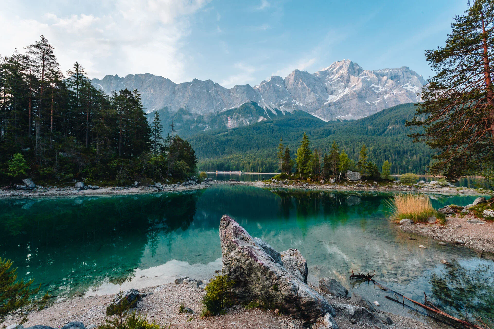 Picture of a lake surrounded by trees with mountains in the background