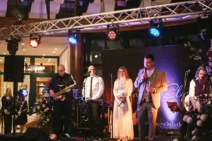 A group of people on a stage at a concert with musical instruments.
