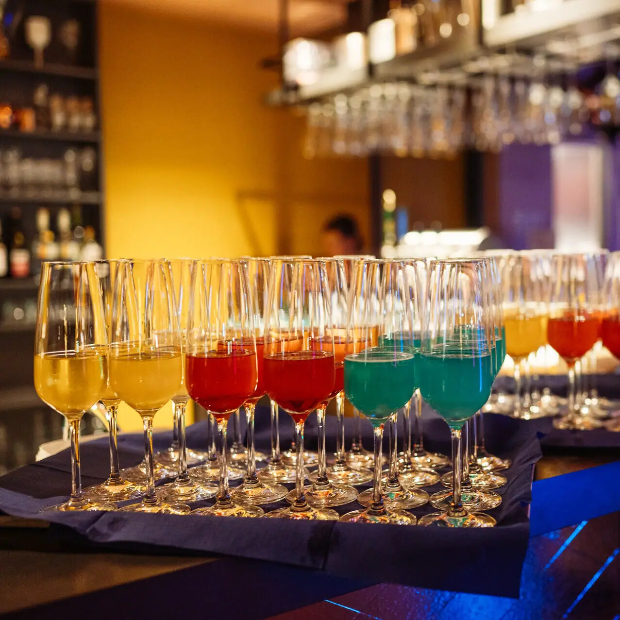 A group of glasses with different coloured drinks.