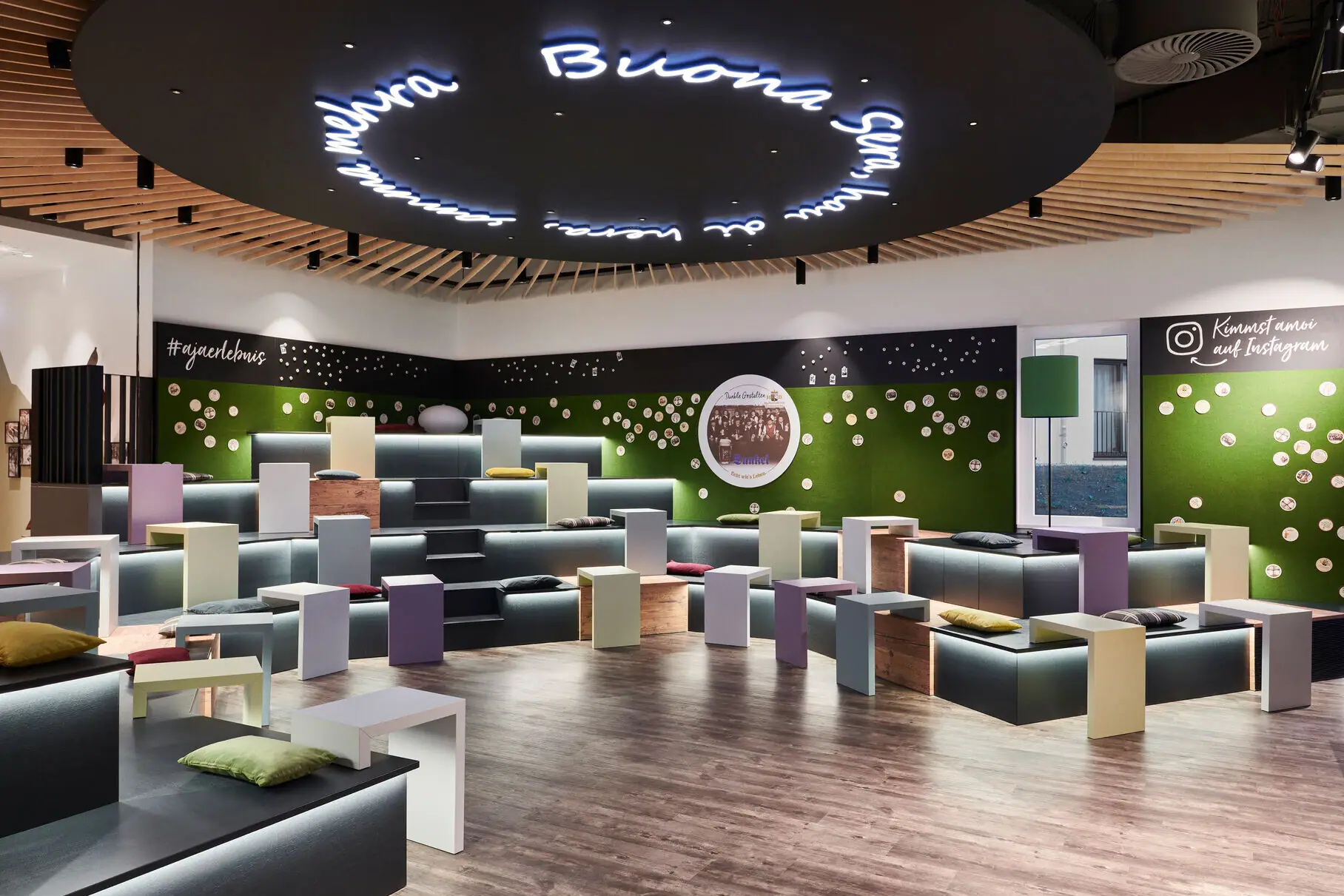 A room with lots of colourful benches and tables.