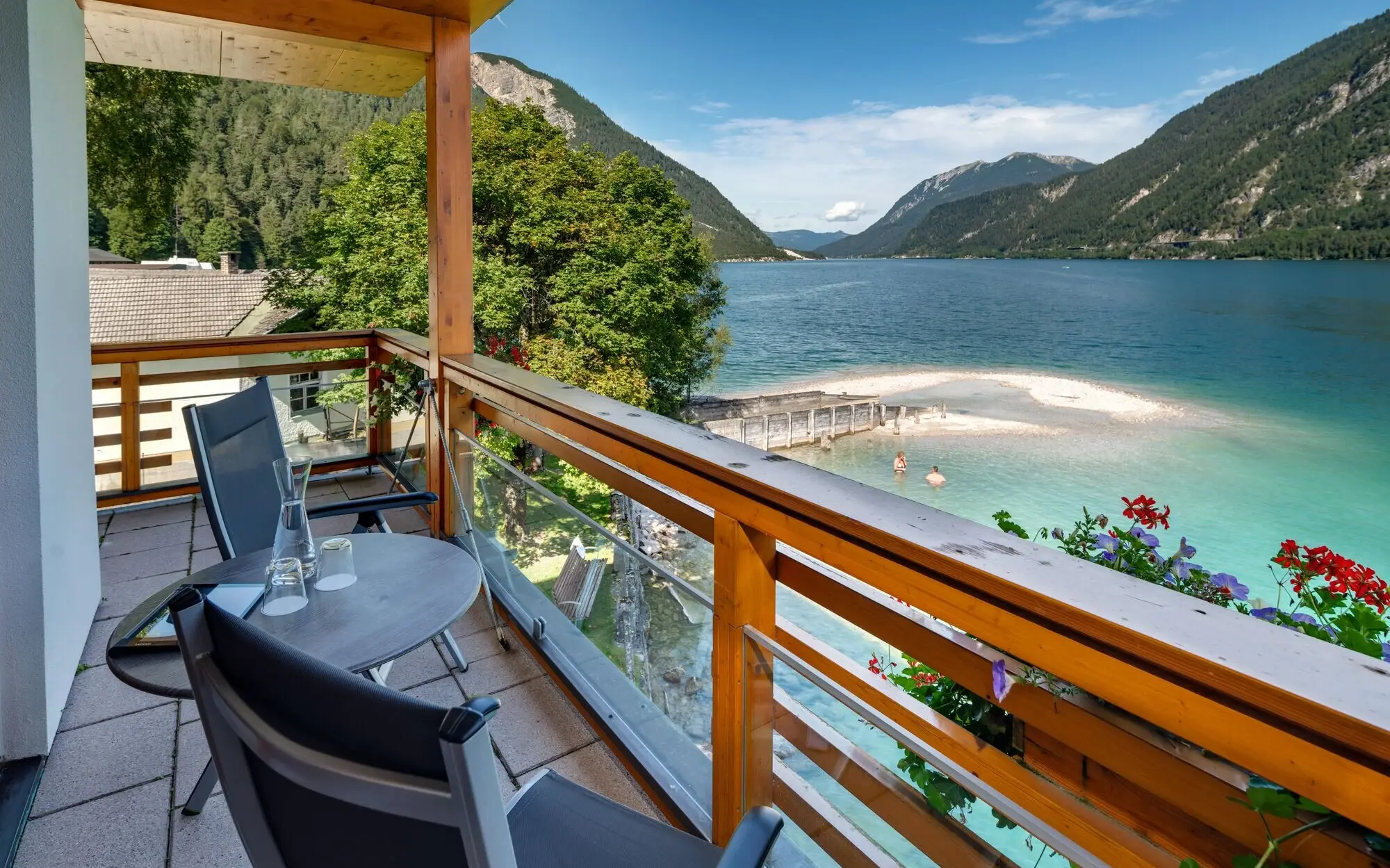 Balcony with table and chairs overlooking a body of water.