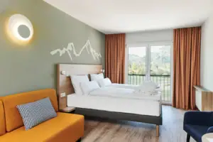 Double room mountain view aja Ruhpolding A room with two beds and a sofa.