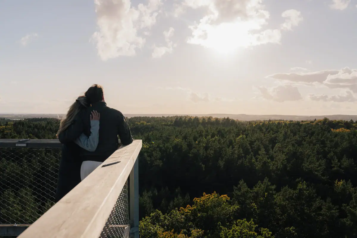 View treetop walk Usedom A man and a woman embrace on a balcony with a view of the treetop path