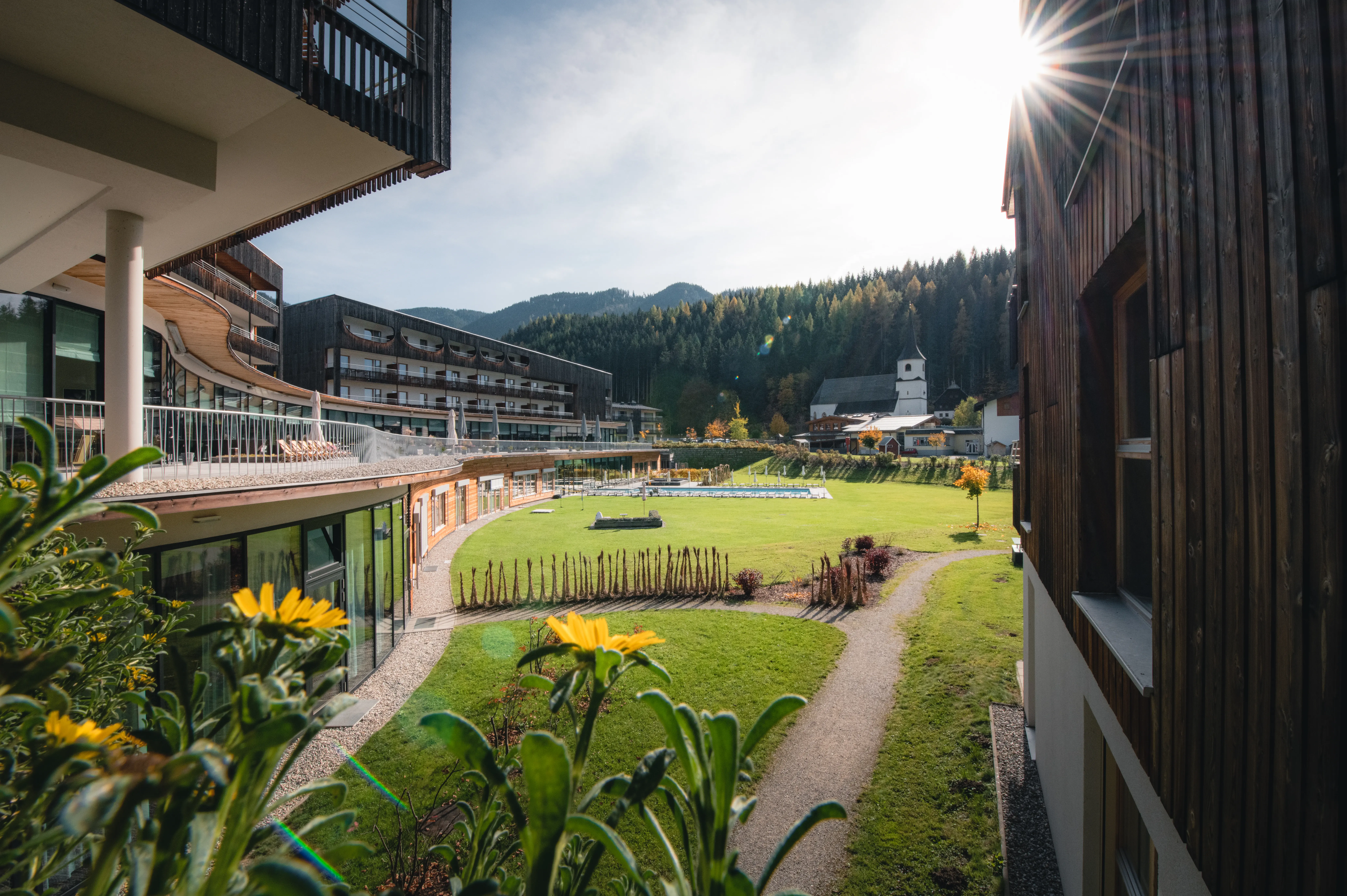Green meadow with trees and buildings in the background.