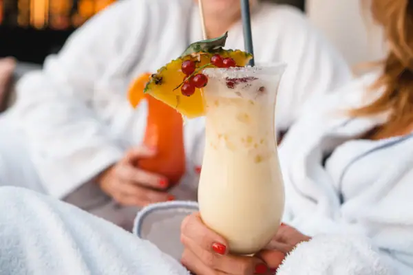 A woman holds a drink.