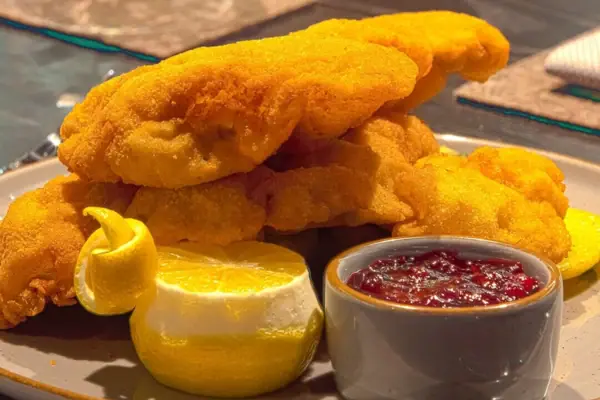 A plate of deep-fried food and sauces.