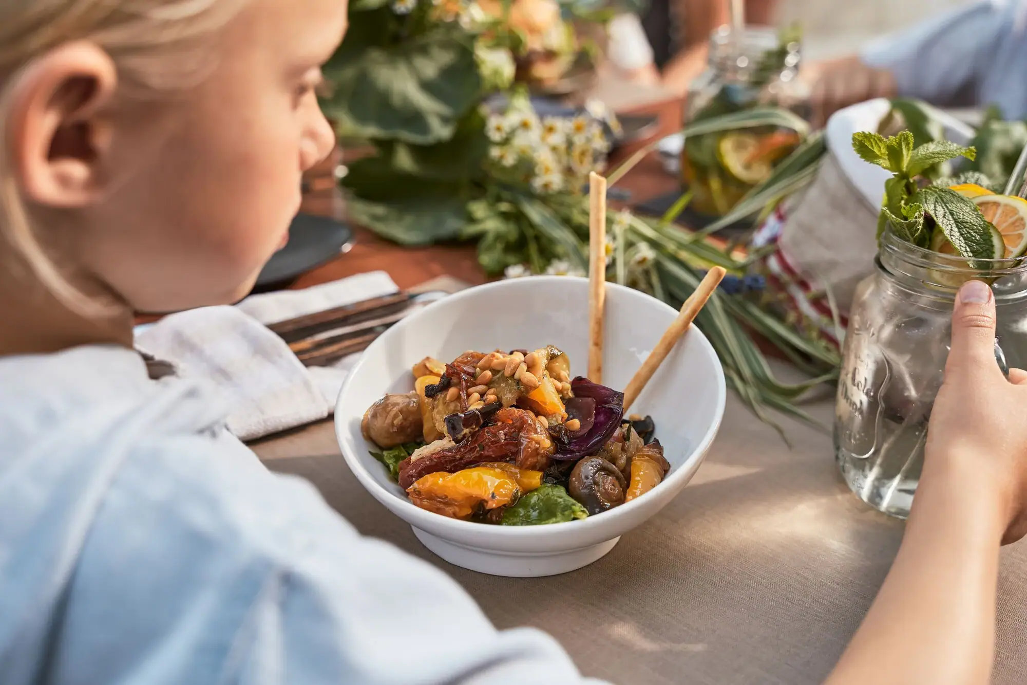 Person sits at a table with a bowl of food.