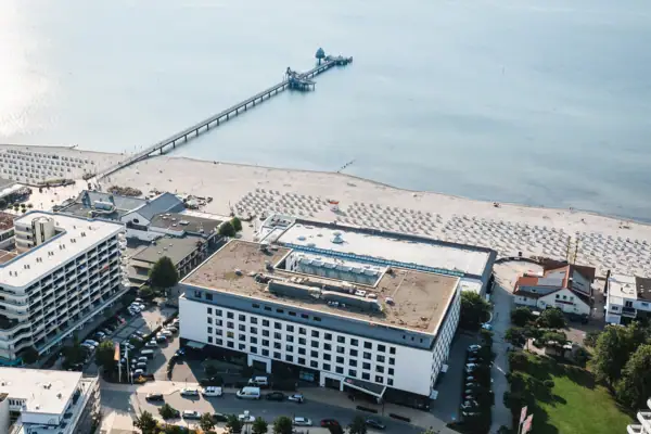 Luftaufnahme eines Strandes mit angrenzenden Gebäuden.