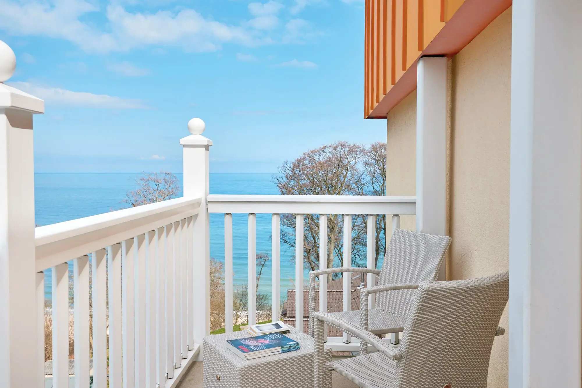 Balcony view A white chair and table on a balcony overlooking the sea.