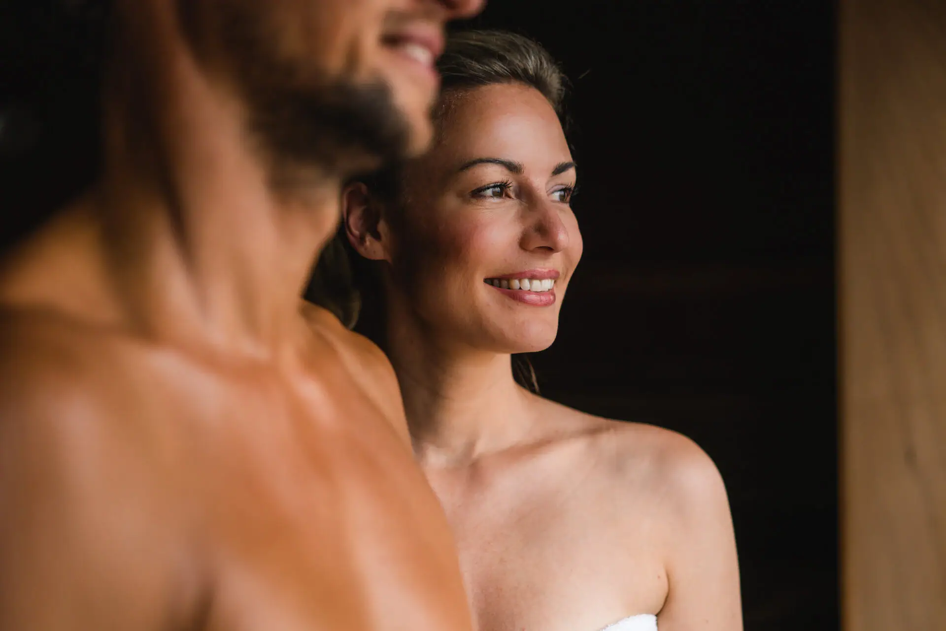 BIO sauna at aja Warnemünde A man and a woman are smiling and standing in a sauna.