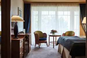 A room with a bed, a table and chairs.