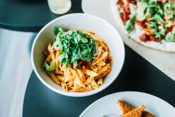 Pasta A bowl of pasta with sauce and parsley.