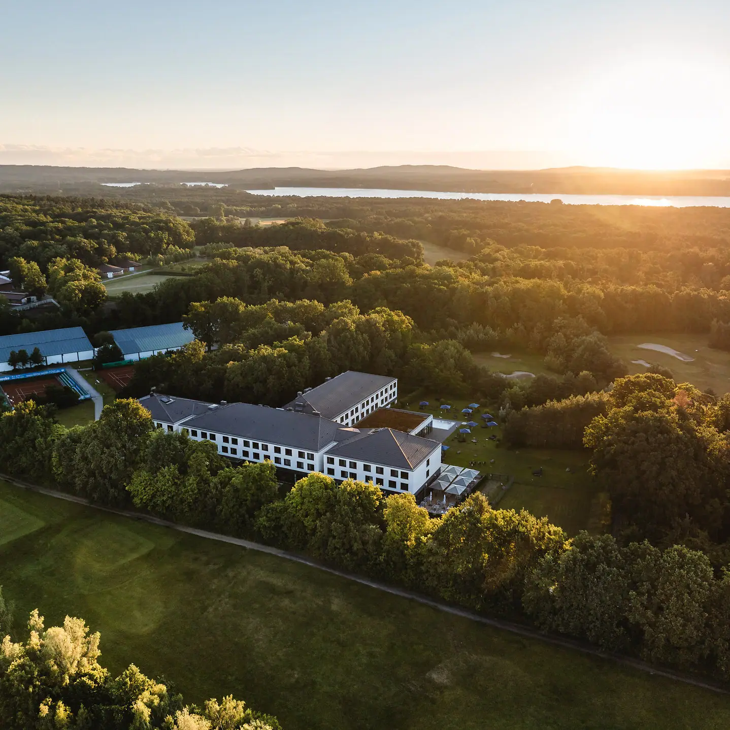 aja Bad Saarow A building surrounded by trees and a body of water.