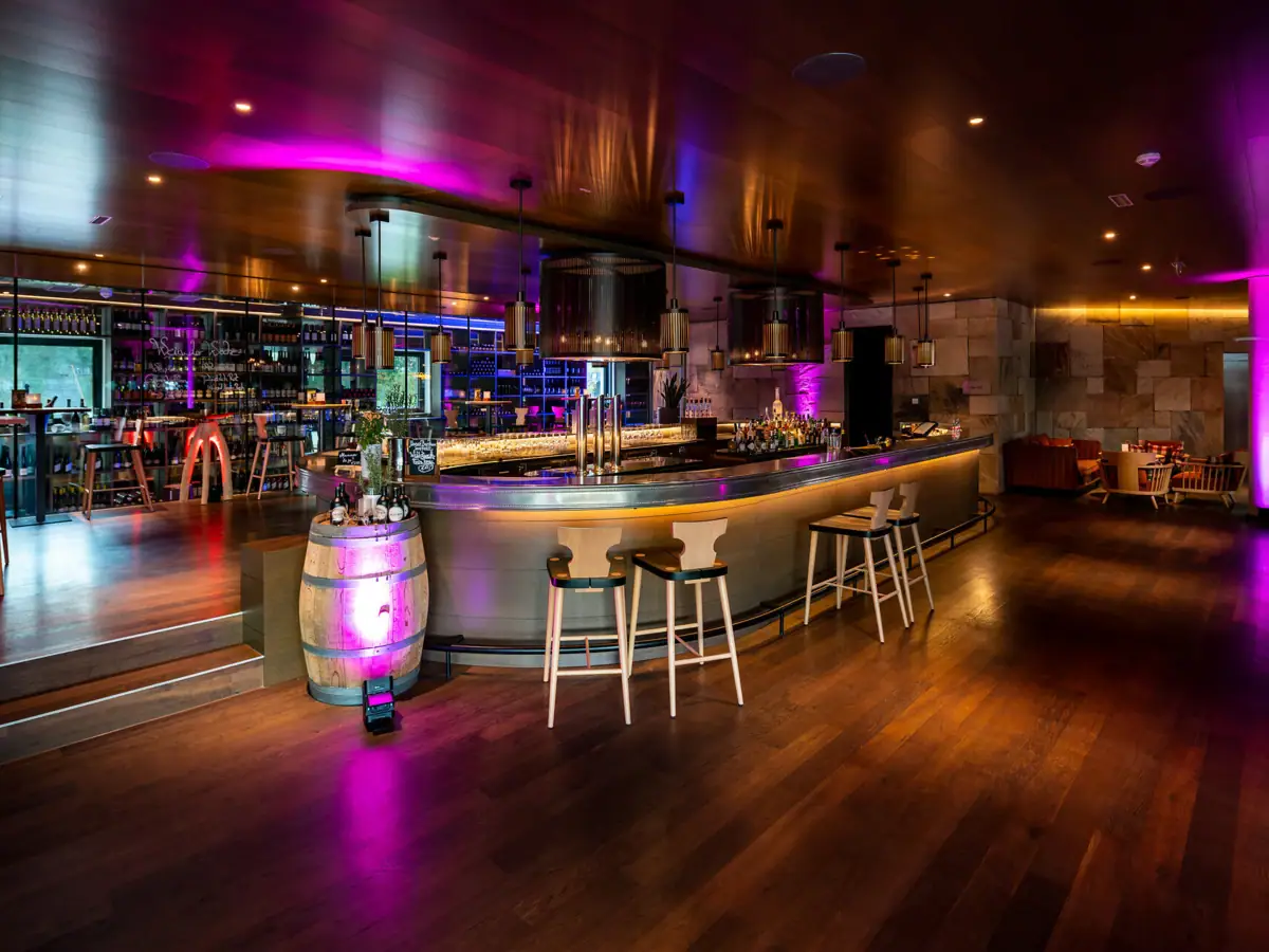 A barrel and stools at a bar.