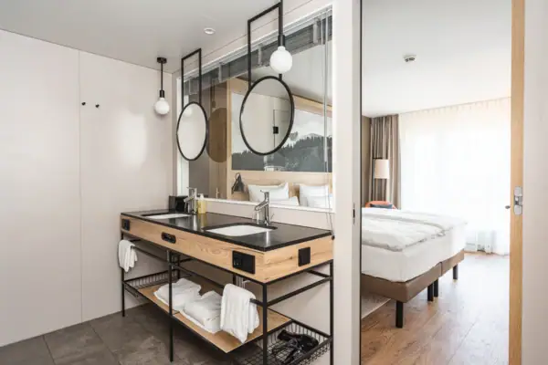 A bathroom with double washbasin and mirror.
