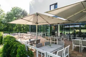 Eine Terrasse mit Tischen und Stühlen.